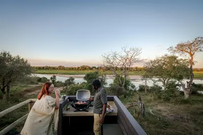 a man and a woman standing on the back of a truck at Nkuhlu Tented Camp in Skukuza