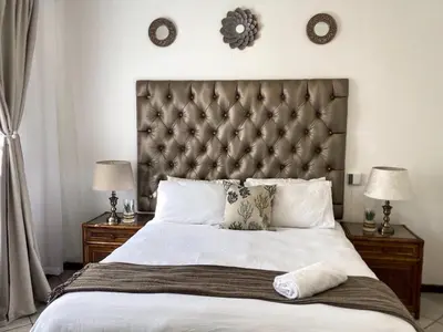 a bedroom with a large bed with two night stands at Siena Sun Luxury Suites 3 in Midrand