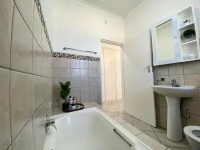 a white bathroom with a tub and a sink at Siena Sun Luxury Suites 3 in Midrand