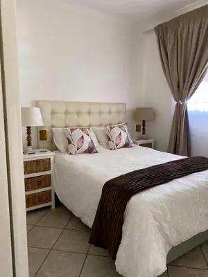 a bedroom with a large white bed with two pillows at Siena Sun Luxury Suites 3 in Midrand