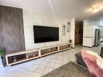 a living room with a flat screen tv on a wall at Siena Sun Luxury Suites 3 in Midrand