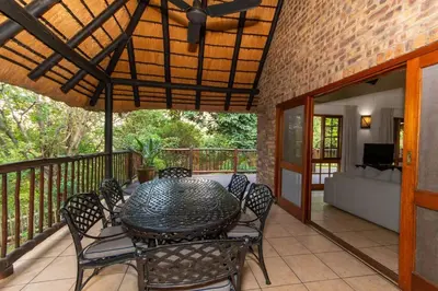 a patio with a table and chairs on a balcony at Kruger Park Lodge Unit No. 254 in Hazyview
