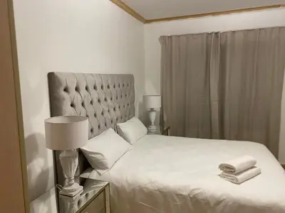 a bedroom with a white bed with two towels on it at Siena Sun Apartment 6 with water reserve in Midrand