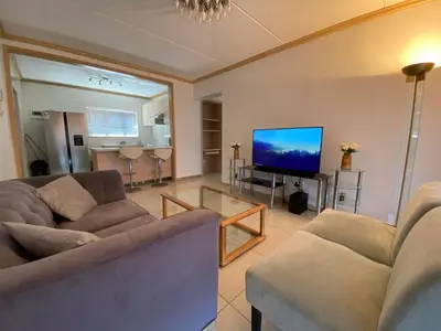 a living room with two couches and a flat screen tv at Siena Sun Apartment 6 with water reserve in Midrand
