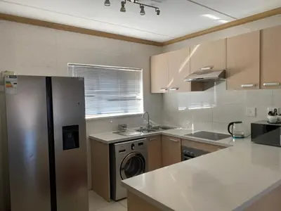 a kitchen with a stainless steel refrigerator and a dishwasher at Siena Sun Apartment 6 with water reserve in Midrand