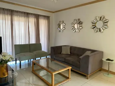 a living room with a couch and a coffee table at Siena Sun Apartment 6 with water reserve in Midrand