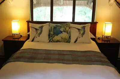 a bedroom with a large bed with two lamps at House On Blyde in Kampersrus AH