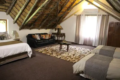 a bedroom with two beds and a couch and a window at House On Blyde in Kampersrus AH