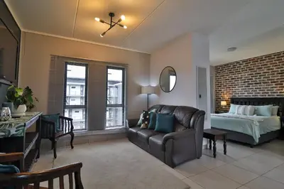 a living room with a couch and a bed at Luxury Lowveld Apartment in Nelspruit