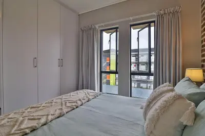 a bedroom with a bed and a large window at Luxury Lowveld Apartment in Nelspruit