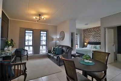a living room with a couch and a table and a bed at Luxury Lowveld Apartment in Nelspruit