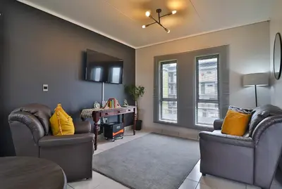 a living room with two chairs and a desk at Luxury Lowveld Apartment in Nelspruit