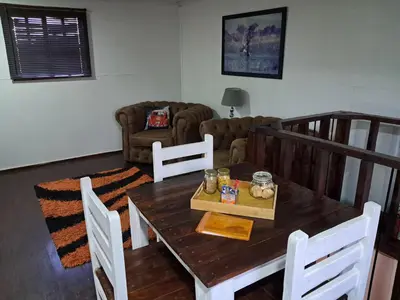 a living room with a wooden table and chairs at Sable Sunset Guesthouse in Trichardt