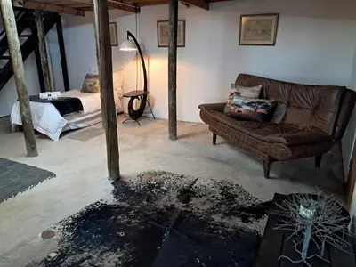 a living room with a couch and a bed at Sable Sunset Guesthouse in Trichardt