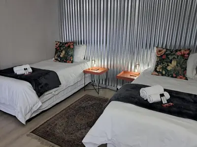 a room with two beds and two tables with candles at Sable Sunset Guesthouse in Trichardt