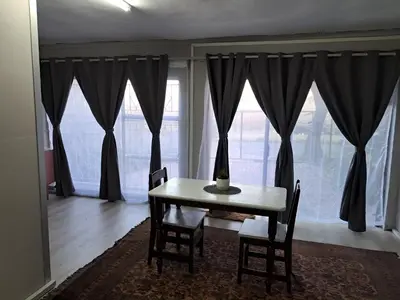 a dining room table and chairs in front of a window at Sable Sunset Guesthouse in Trichardt