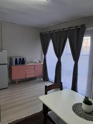 a living room with a table and a kitchen at Sable Sunset Guesthouse in Trichardt