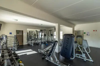 a gym with several treadmills and machines in it at The Sunrise in Midrand