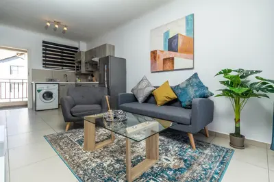 a living room with a couch and two chairs and a table at The Sunrise in Midrand