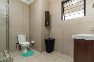 a bathroom with a toilet and a sink at The Sunrise in Midrand