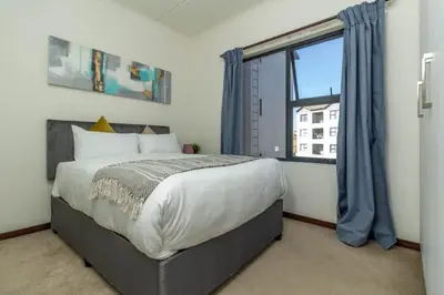a bedroom with a bed and a large window at The Grandeur- with back up power in Midrand