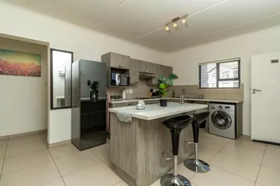 a large kitchen with a sink and a dishwasher at The Grandeur- with back up power in Midrand