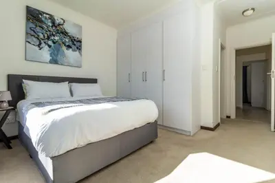 a bedroom with a large bed and white walls at The Grandeur- with back up power in Midrand