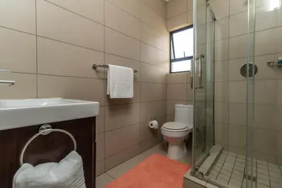 a bathroom with a toilet and a sink and a shower at The Grandeur- with back up power in Midrand