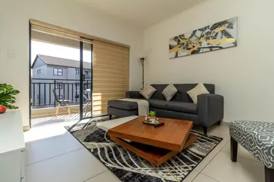 a living room with a couch and a table at The Grandeur- with back up power in Midrand