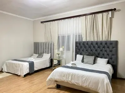 a bedroom with two beds and a window at Siena Sun Guesthouse Rooms and Breakfast Option in Midrand