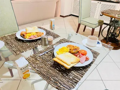 two plates of breakfast foods on a table at Siena Sun Guesthouse Rooms and Breakfast Option in Midrand