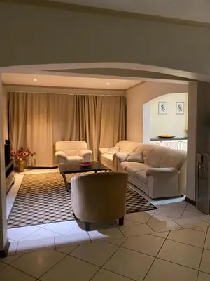 a living room with a couch and a table and chairs at Siena Sun Guesthouse Rooms and Breakfast Option in Midrand
