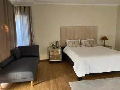 a bedroom with a bed and a chair at Siena Sun Guesthouse Rooms and Breakfast Option in Midrand