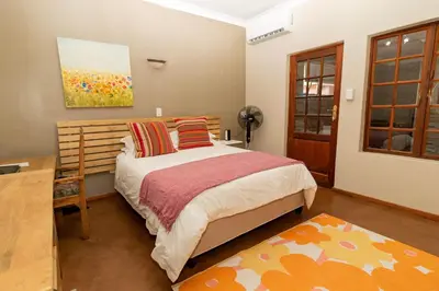 a bedroom with a bed and a painting on the wall at Somethin Special in Mokopane