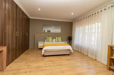 a bedroom with a bed and a large window at Somethin Special in Mokopane