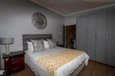 a bedroom with a bed and a mirror on the wall at Somethin Special in Mokopane