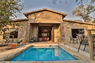 a house with a swimming pool in front of a building at NoNaMe in Marloth Park