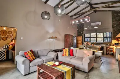 a living room with two couches and a kitchen at NoNaMe in Marloth Park