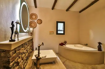 a bathroom with a large tub and a sink at NoNaMe in Marloth Park