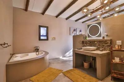 a bathroom with a tub and a sink and a mirror at NoNaMe in Marloth Park