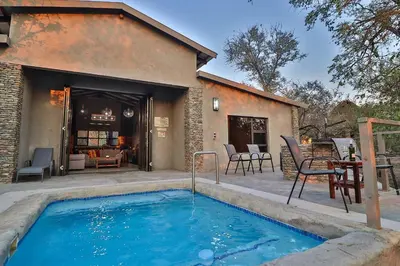 a swimming pool in front of a house at NoNaMe in Marloth Park