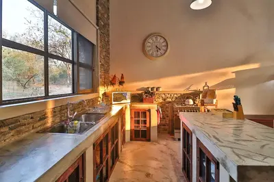 a kitchen with a sink and a clock on the wall at NoNaMe in Marloth Park