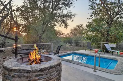 a fire pit next to a swimming pool with a fire grill at NoNaMe in Marloth Park