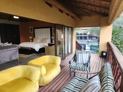 a porch with a bed and a couch and chairs at The Elias Resort in Septimus