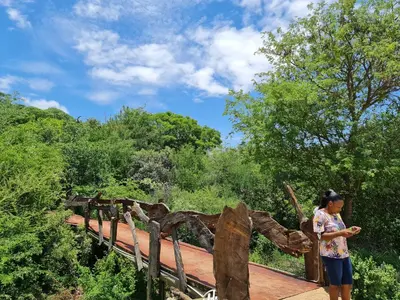 a woman standing on a bridge over a wooden walkway at The Elias Resort in Septimus