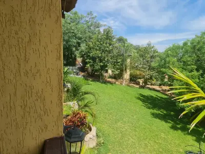 a yard with green grass and trees and a building at The Elias Resort in Septimus