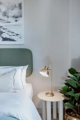 a bedroom with a bed and a table with a lamp at Circa Aparthotel by Totalstay in Pretoria