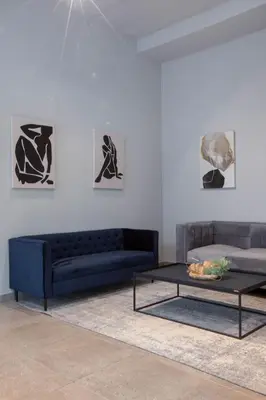 a living room with a blue couch and a coffee table at Circa Aparthotel by Totalstay in Pretoria