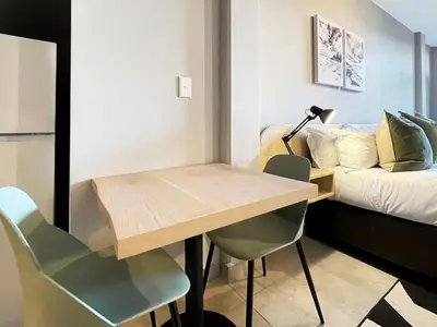 a room with a table and chairs and a bed at Circa Aparthotel by Totalstay in Pretoria