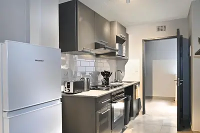 a kitchen with stainless steel appliances and a refrigerator at Circa Aparthotel by Totalstay in Pretoria